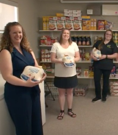 Women holding turkey in a grocery store