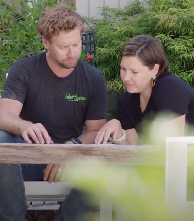 Man and woman sit looking at something on a table