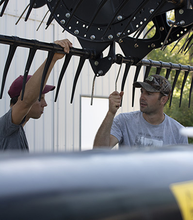 Farmers standing in front of combine header