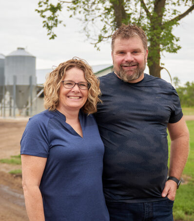 Chicken Farmers in front of their barn
